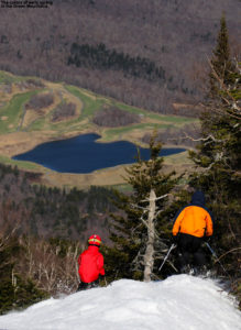 An image of skiers above the valley in spring at Stowe Mountain Resort in Vermont