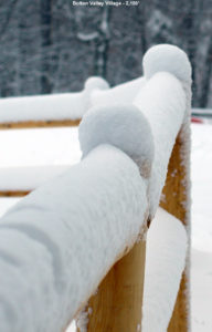 An image of fresh snow on a fence in the Village at Bolton Valley Ski Resort in Vermont