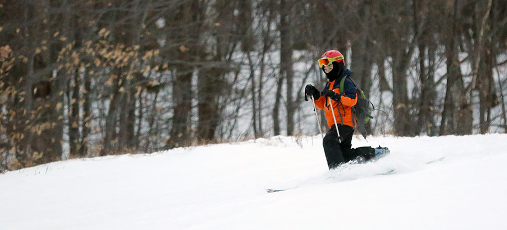 An image of Dylan Telemark skiing in powder at Bolton Valley Ski Resort in Vermont
