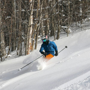 An image of Ty skiing powder on the Spell Binder trail at Bolton Valley Resort in Vermont