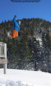 An image of Ty taking a huge jump off the railing of the Wilderness Summit Ski Patrol Hut into deep powder below at Bolton Valley Resort in Vermont