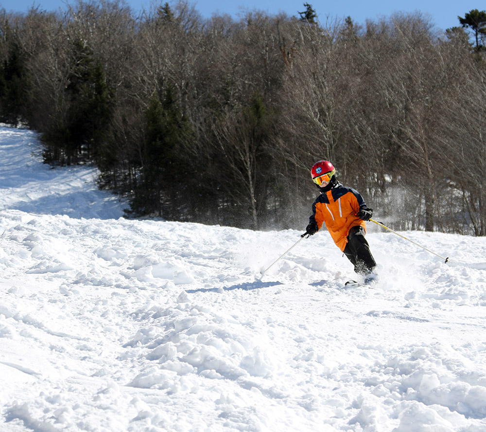 An image of Dylan Telemark skiing in chopped up snow on the Tattle Tale trail at Bolton Valley Resort in Vermont