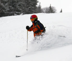 An image of Dylan skiing powder on the Tattle Tale trail at Bolton Valley Resort in Vermont
