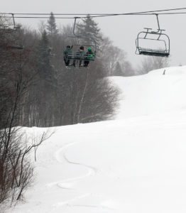 An image of skiers on the Timberline Chairlift at Bolton Valley ski resort on Vermont