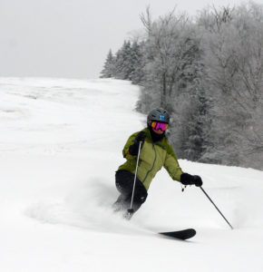 An image of Erica Telemark skiing in powder at Bolton Valley Resort in Vermont