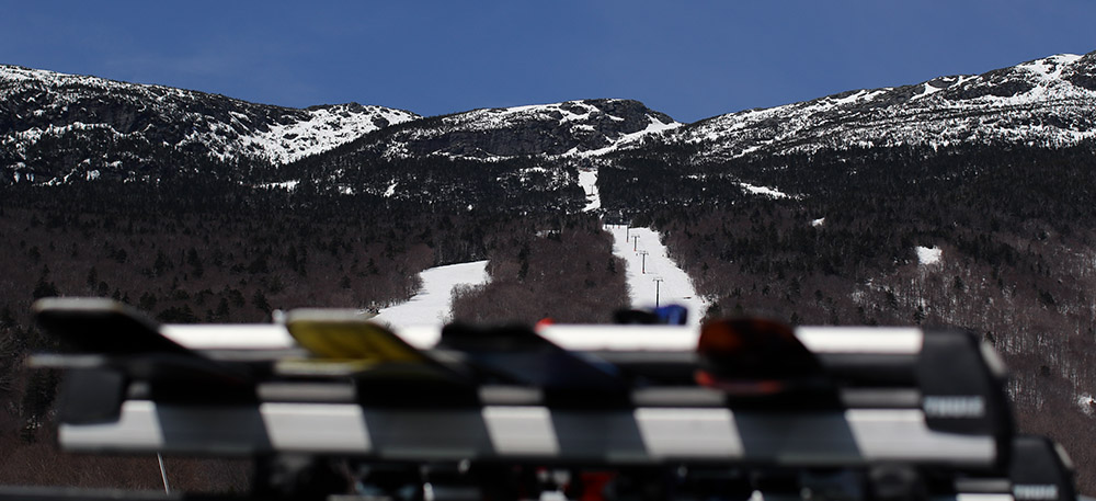 An image of Mt. Mansfield in above a ski rack on a clear day in the spring at Stowe Mountain Resort in Vermont