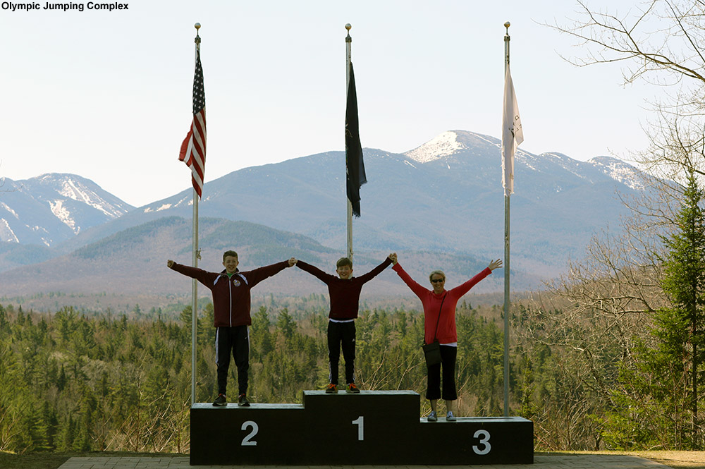 An image of Erica and the boys on the podiums at the Lake Placid Olympic Jumping Complex