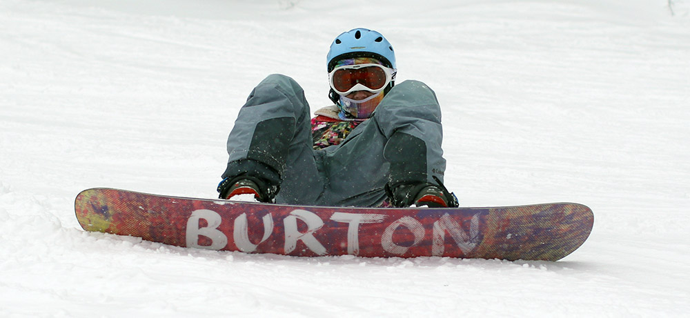 An image of Molly waiting on the trail on her snowboard at Stowe Mountain Resort in Vermont