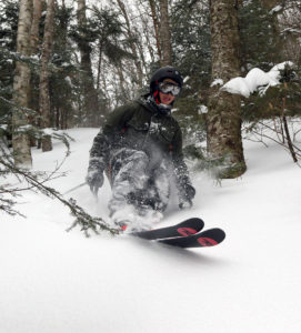 An image of Wiley skiing powder in the Hazelton Zone at Stowe Mountain Resort in Vermont