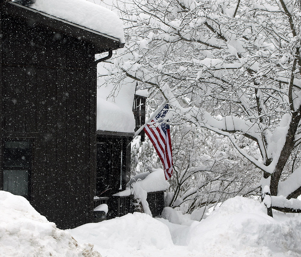 An image of a house with fluffy snow accumulations along the Bolton Valley Access Road near Bolton Valley Ski Resort in Vermont