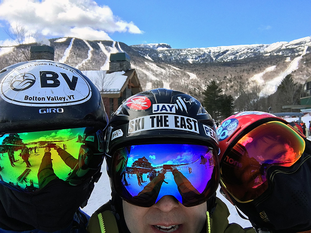 an image of Ty, Jay, and Dylan wearing Anon M2 goggles with various lenses with the trails of Stowe Mountain Resort in Vermont in the background