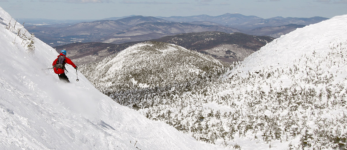 An image of Jonah skiing Mt. Mansfield below the Hourglass Chute with the Mt. Mansfield Adam's Apple in the background