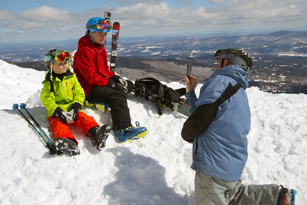 An image of Josh taking a photo of Agi and Jonah on the Mt. Mansfield ridgeline during an ascent to the Chin of Mt. Mansfield in Vermont