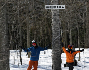 An image of Ty and Dylan underneath the sign for the Warlock trail at Magic Mountain in Vermont
