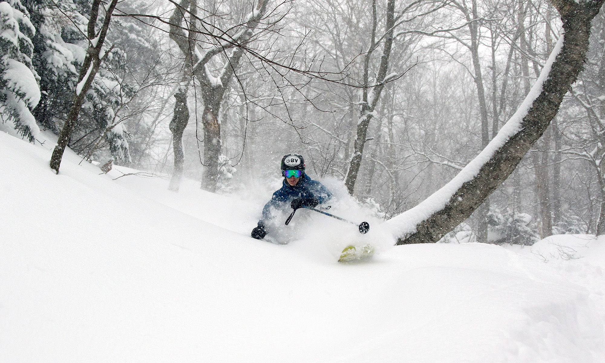 An image of Ty skiing deep powder on the Ravine trail at Stowe Mountain Resort in Vermont during Winter Storm Stella