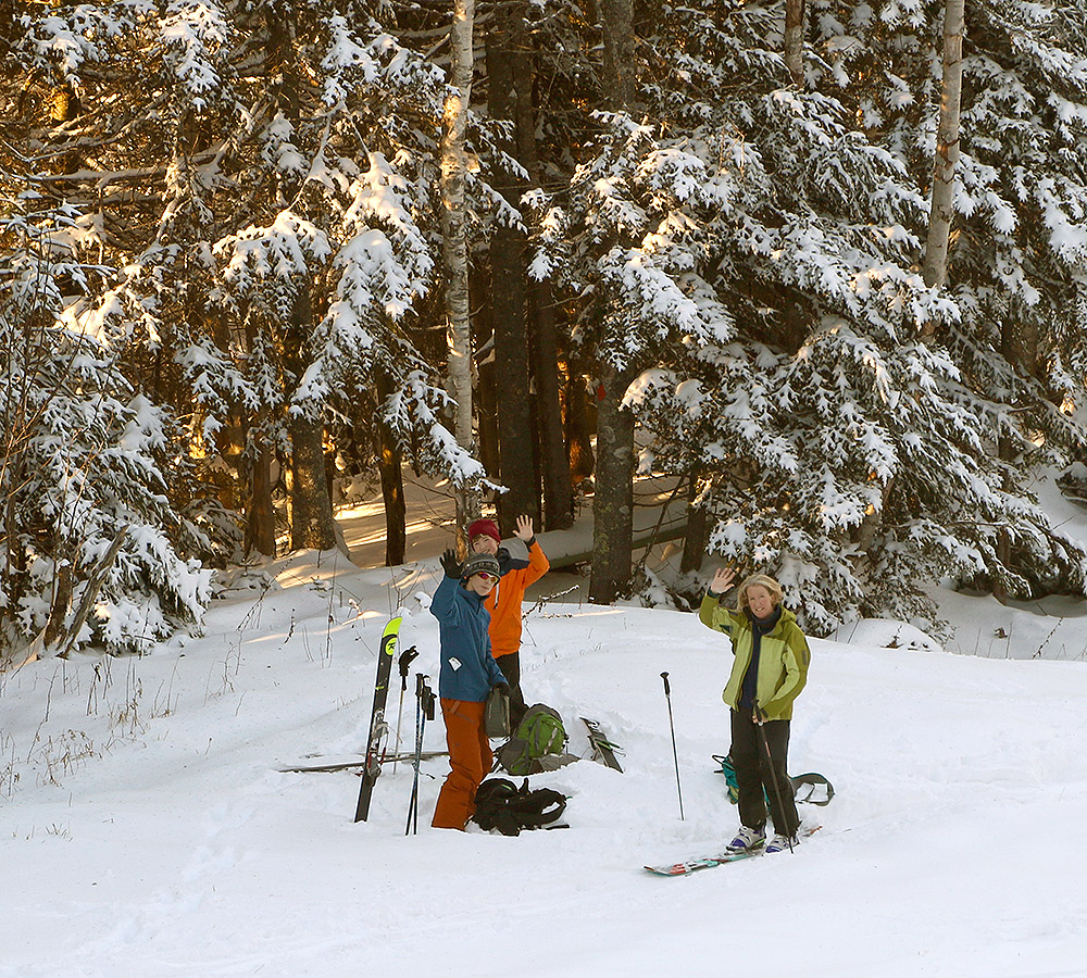 An image of Erica, Ty, and Dylan waving hello on their first ski tour of the season at Bolton Valley Resort in Vermont