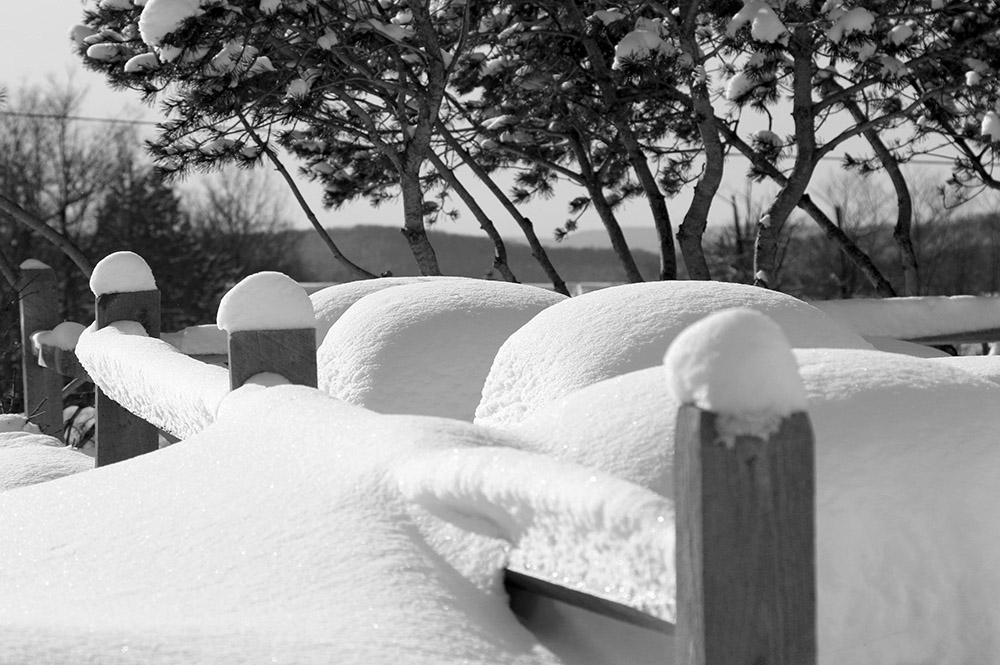 An image of snow on railings and tables in the Village at Bolton Valley Ski Resort in Vermont