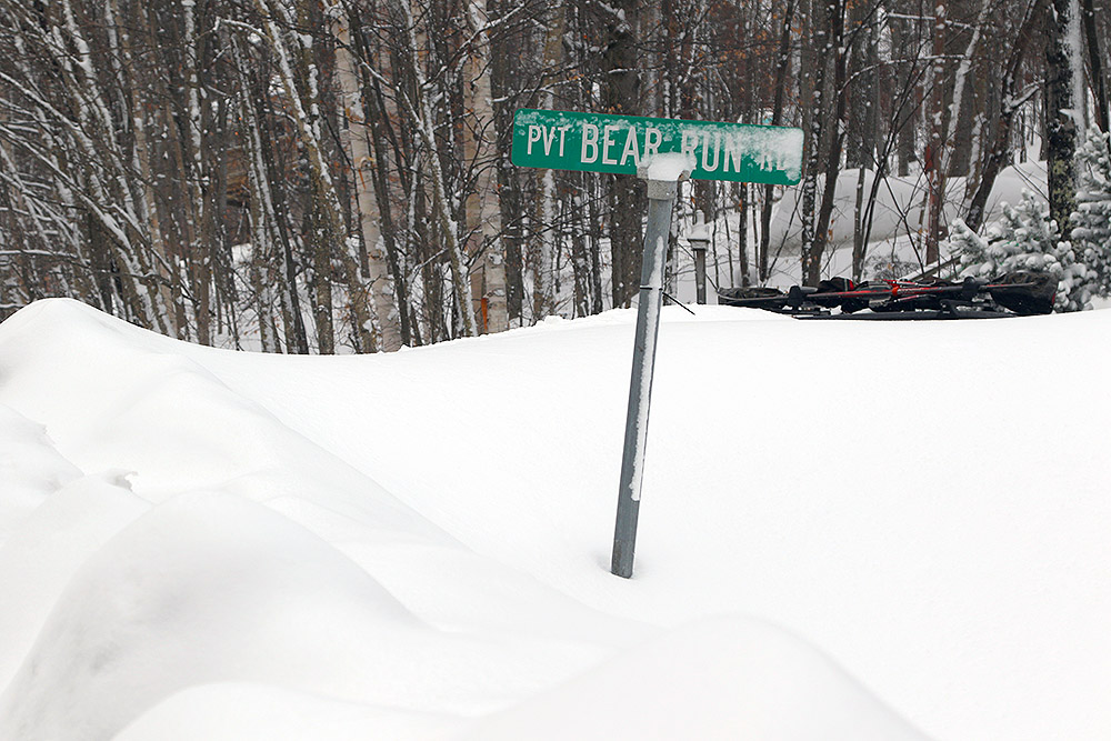 An image of the Bear Run street sign in deep snowbanks along the Bolton Valley Access Road near Bolton Valley Ski Resort in Vermont