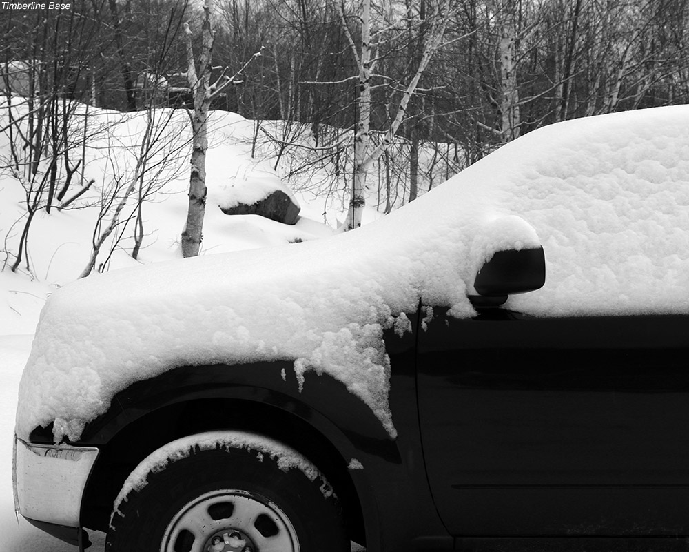 An image of a car with fresh snow on it in the parking area near the Timberline Base Lodge at Bolton Valley Ski Resort in Vermont
