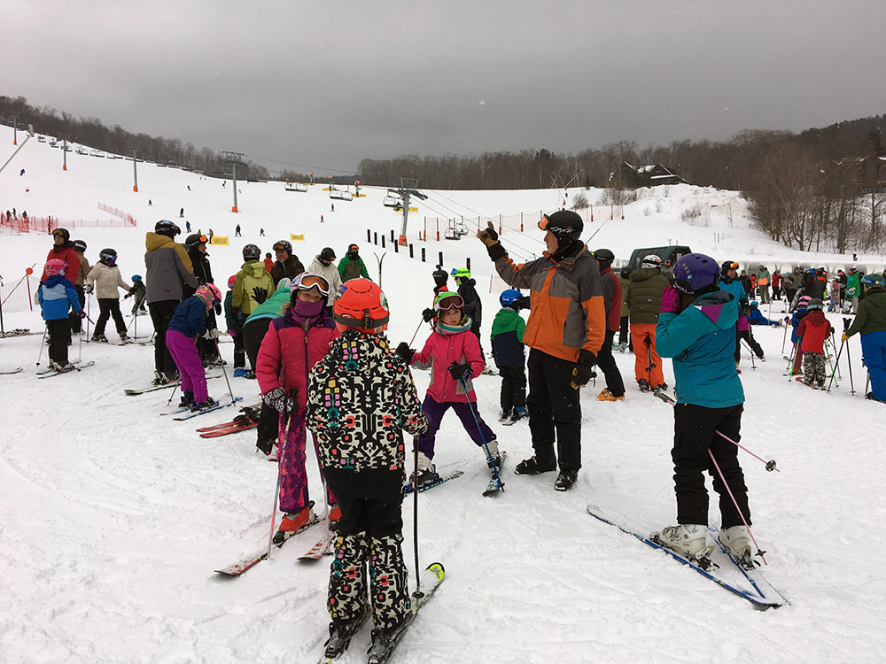 An image of participants grouping up for our weekly BJAMS ski program at the base of Spruce Peak at Stowe Mountain Resort in Vermont