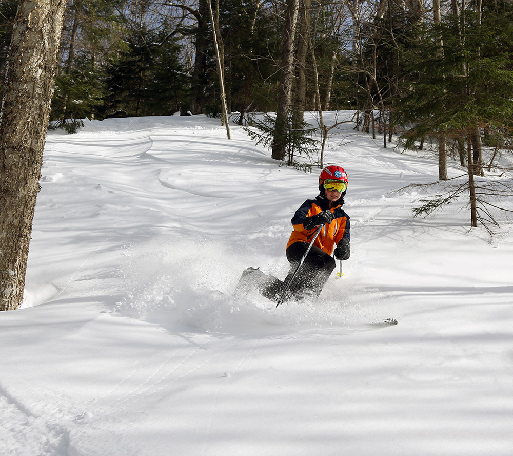 An image of Dylan Telemark skiing in powder on Maria's at Bolton Valley Resort in Vermont