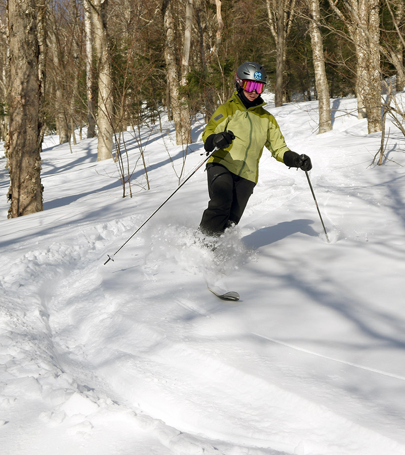 An image of Erica skiing powder in the Snow Hole area at Bolton Valley Resort in Vermont