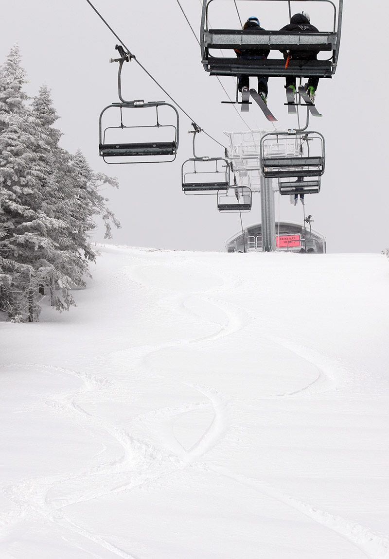 An image of ski tracks in powder below the Sensation Quad Chairlift at Stowe Mountain Resort during Winter Storm Taylor