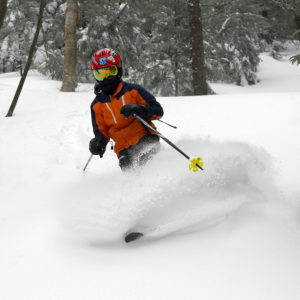 An image of Dylan skiing in powder at Bolton Valley Ski Resort in Vermont