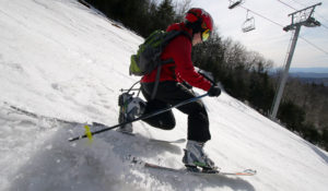 An image of Dylan Telemark skiing in spring snow on the Spillway trail at Bolton Valley Resort in Vermont