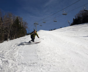An image of Jay Telemark skiing in spring snow on the Spillway trail at Bolton Valley Resort in Vermont