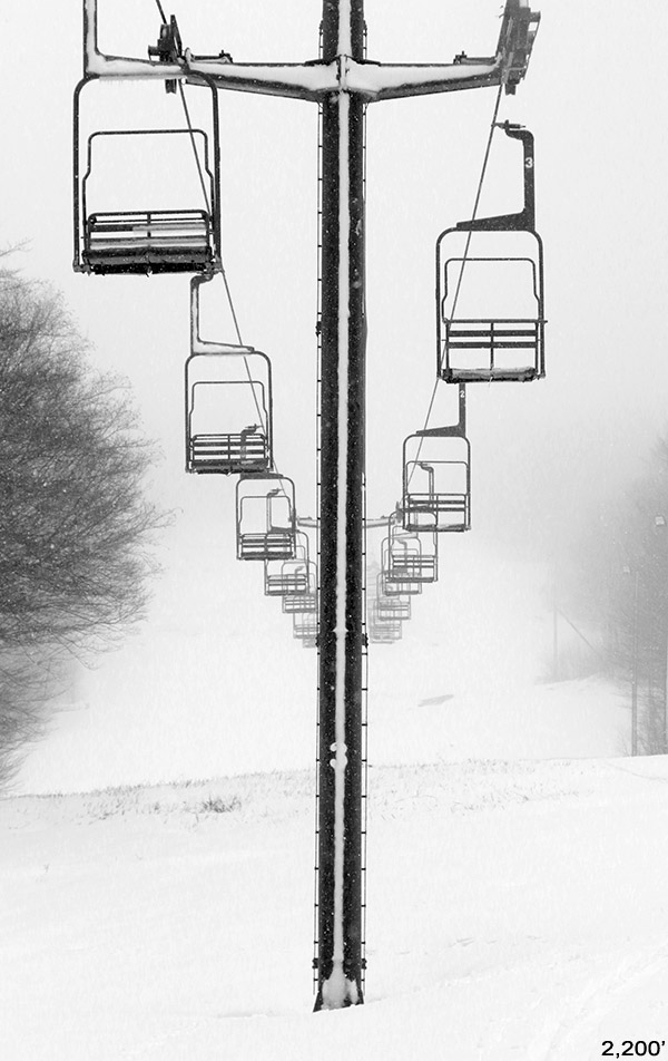 An image of the Mid Mountain Double Chairlift at Bolton Valley Ski Resort in Vermont after a late April snowfall