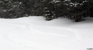 An image of ski tracks in powder snow on the Perry Merrill trail at Stowe Mountain Resort in Vermont after a late April snowfall