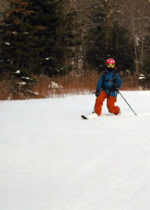 An image of Dylan Telemark skiing in some November powder on the Turnpike trail at Bolton Valley Resort in Vermont.
