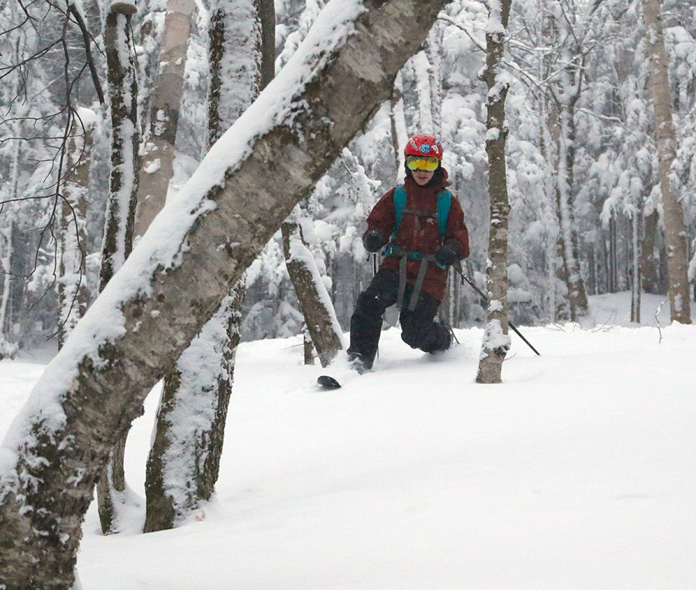 An image of Dylan Telemark skiing in powder on the backcountry network at Bolton Valley Resort in Vermont