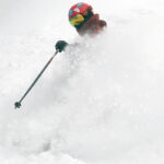 Dylan creating a wall of powder as he skis fresh snow form Winter Storm Odell at Bolton Valley Resort in Vermont