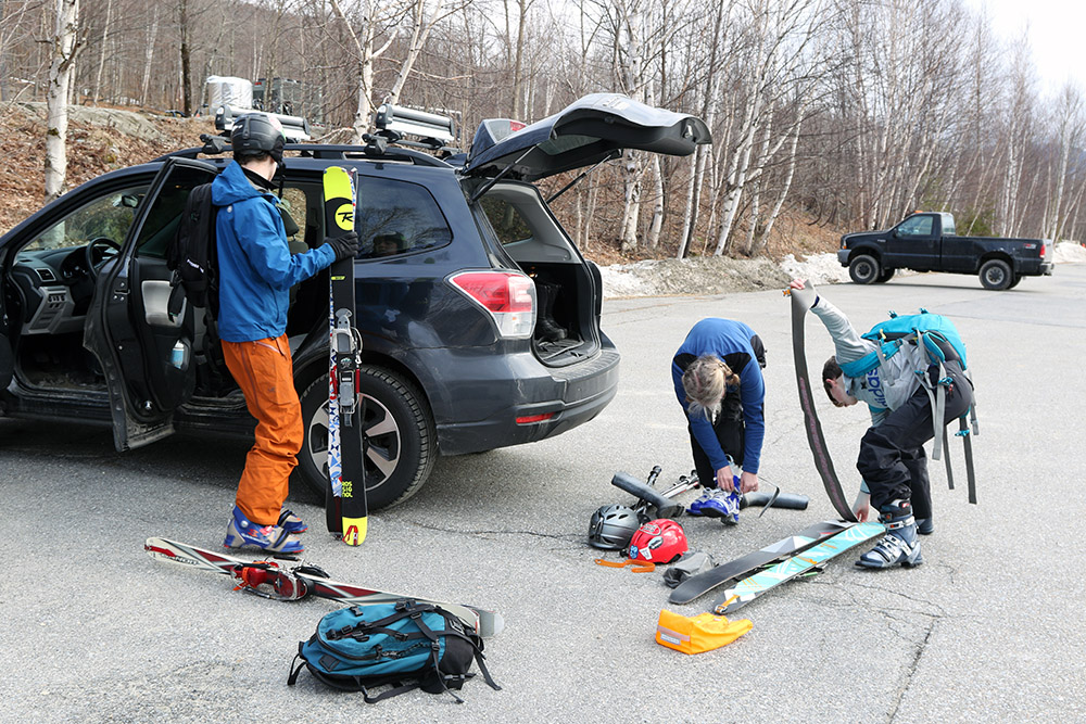 An image of Erica, Ty, and Dylan preparing their gear for a spring ski tour at Bolton Valley Resort in Vermont
