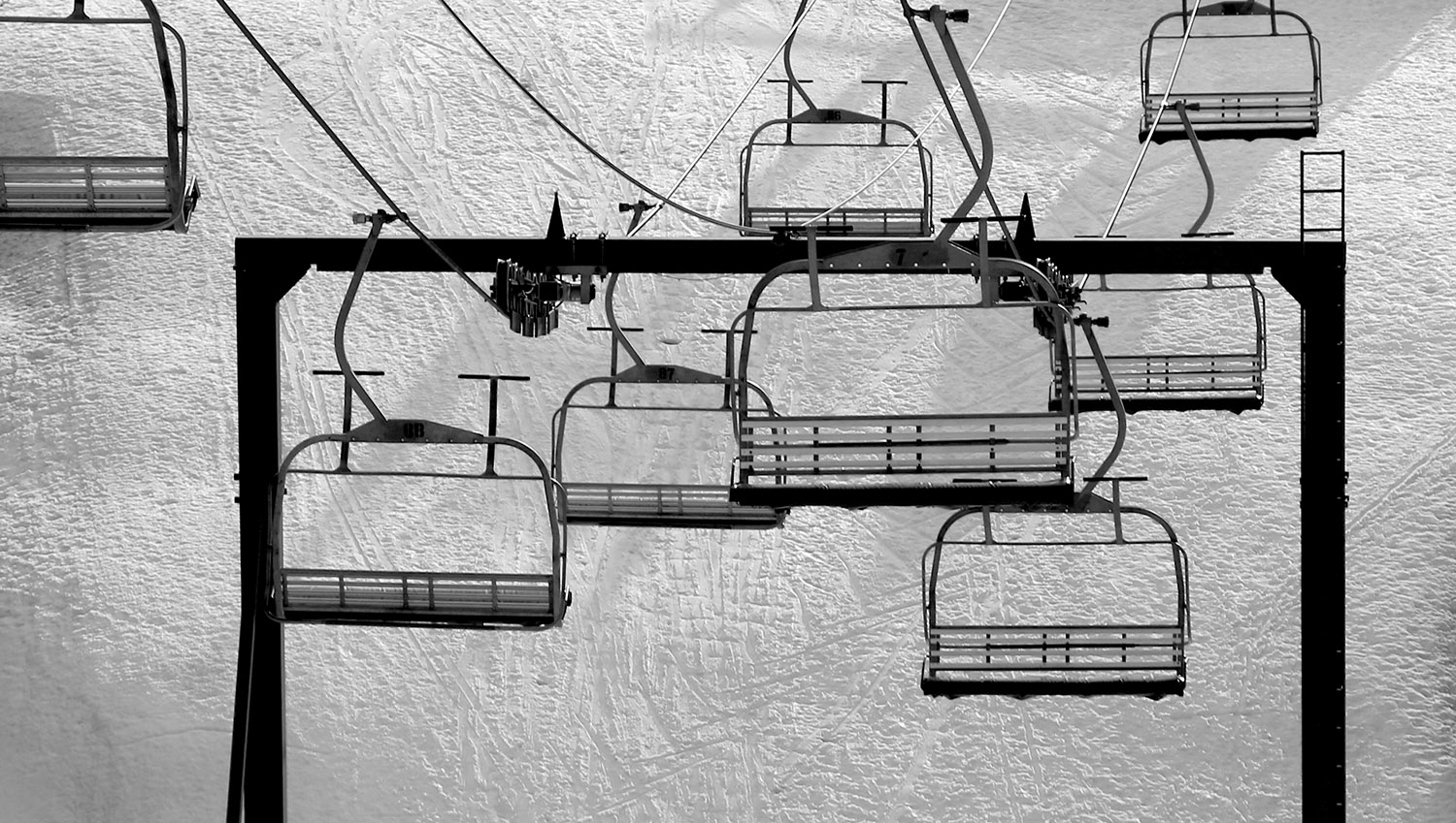 A view of a tower and some of the chairs on the Timberline Quad Chairlift during a spring ski tour at Bolton Valley Resort in Vermont
