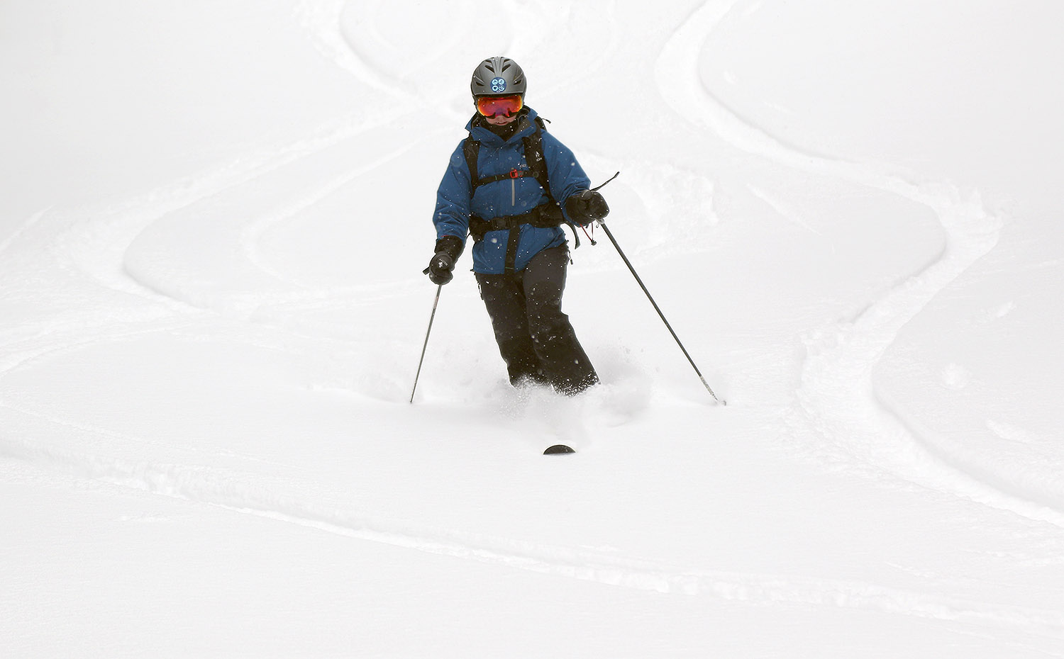 An image of Erica Telemark skiing on powder during an April snowstorm at Bolton Valley Ski Resort in Vermont