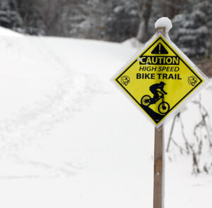 An image of a bike trail sign at Bolton Valley Resort in Vermont while out on a ski tour at the mountain during an early November snowstorm