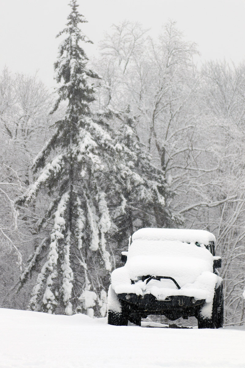 An image of a jeep with trees in the background covered with heavy wet snow from Winter Storm Malcolm at the Timberline Base Area of Bolton Valley Ski Resort in Vermont
