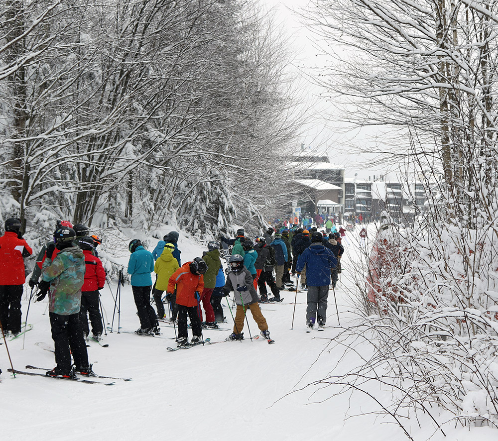 An image of a line of people waiting for the Wilderness Double Chair to open for the first time during the 2020-2021 ski season at Bolton Valley Ski Resort in Vermont