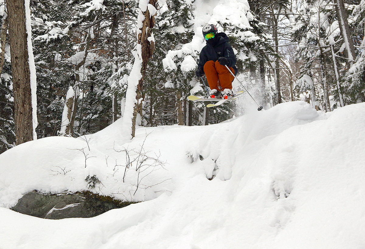 An image of Ty jumping off a ledge on skis in the Wood's Hole area of Bolton Valley Ski Resort in Vermont