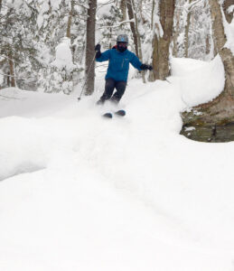 An image of Erica skiing powder from Winter Storm Peggy in the Wood's Hole area at Bolton Valley Ski Resort in Vermont