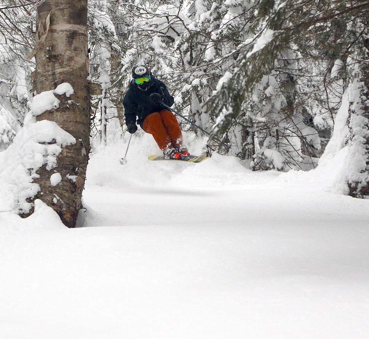 An image of Ty jumping into some untracked powder in a ski line off The Knob at Bolton Valley Ski Resort in Vermont