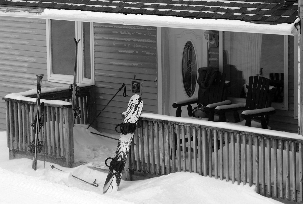 An image of ski gear in the snow on a porch outside a condominium during a March snowstorm at Bolton Valley Ski Resort in Vermont