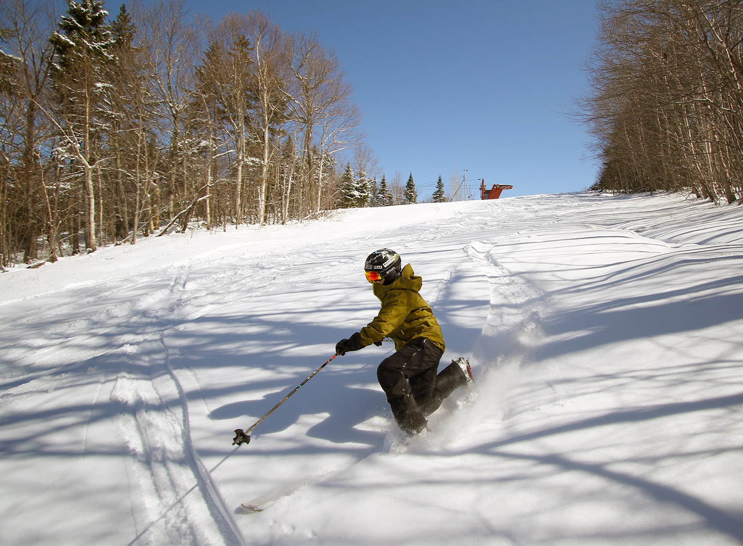 An image of Jay Telemark skiing in powder after an April snowstorm at Bolton Valley Ski Resort in Vermont