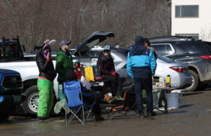 An image showing a group of skiers celebrating the last day of the 2020-2021 ski season in one of the parking lots at Bolton Valley Ski Resort in Vermont