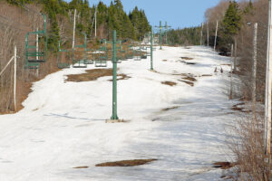 An image of the Beech Seal trail with a couple of people ascending on a warm April dat at Bolton Valley Ski Resort in Vermont