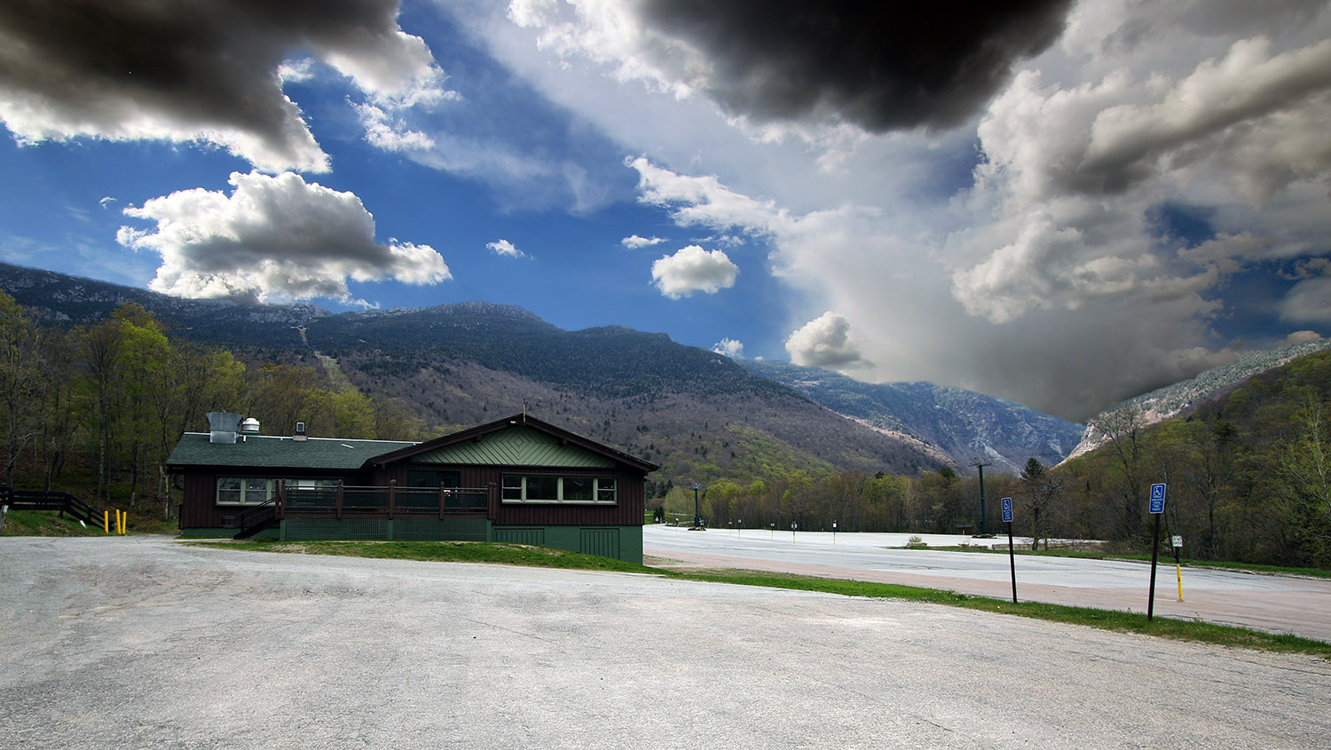 An image from near the Mt. Mansfield Base Lodge showing Smuggler's Notch and various clouds on a spring ski day with thunderstorms in the area near Stowe Mountain Ski Resort in Vermont