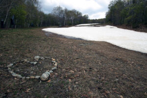 An image of the Lower Standard trail with late-season leftover snow in mid-May at Stowe Mountain Ski Resort in Vermont
